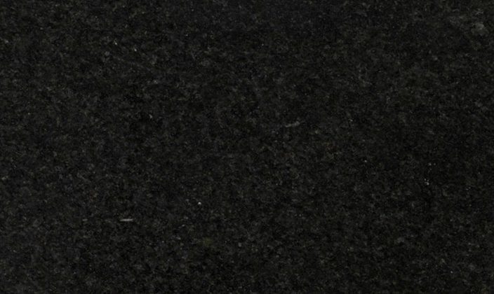 A close-up view of a dark, textured stone surface with a matte finish.