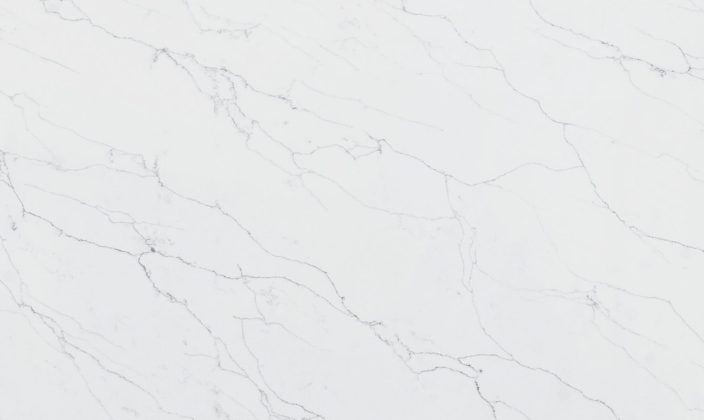 White marble surface with subtle gray veins and natural patterns, creating a smooth and elegant background.