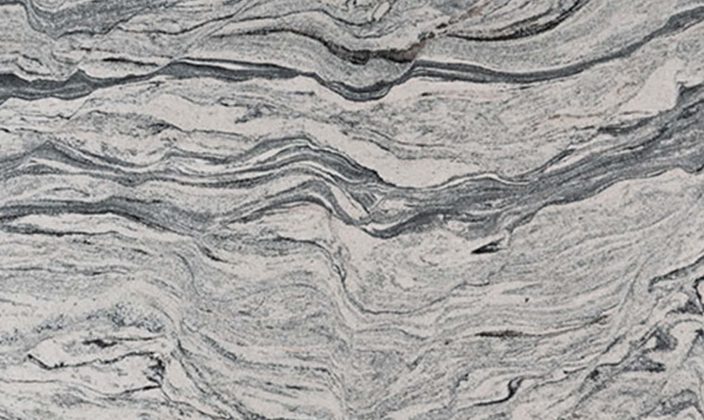 A close-up of a marble surface with gray and white wavy, layered patterns resembling natural stone textures.